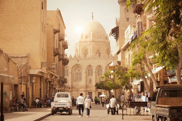 A sunny street in Cairo, Egypt. In the background is a mosque. 