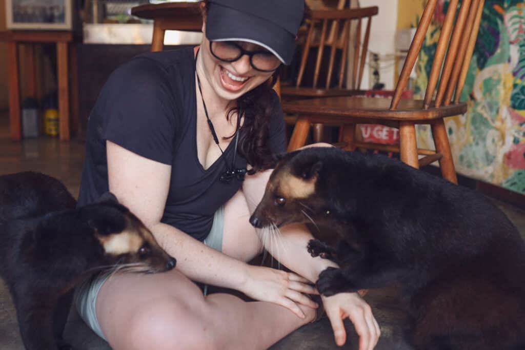 Blogger Katie Caf with two luwaks at a Kopi Luwak coffee cafe in Ubud, Bali. 