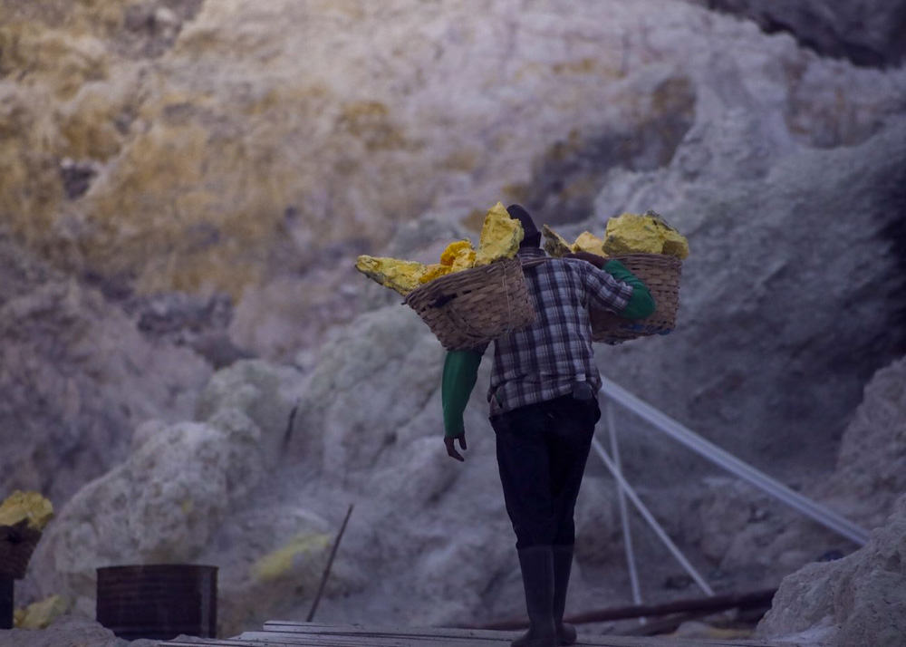 A sulfur miner carries a basket at Mount Kawah Ijen Volcano