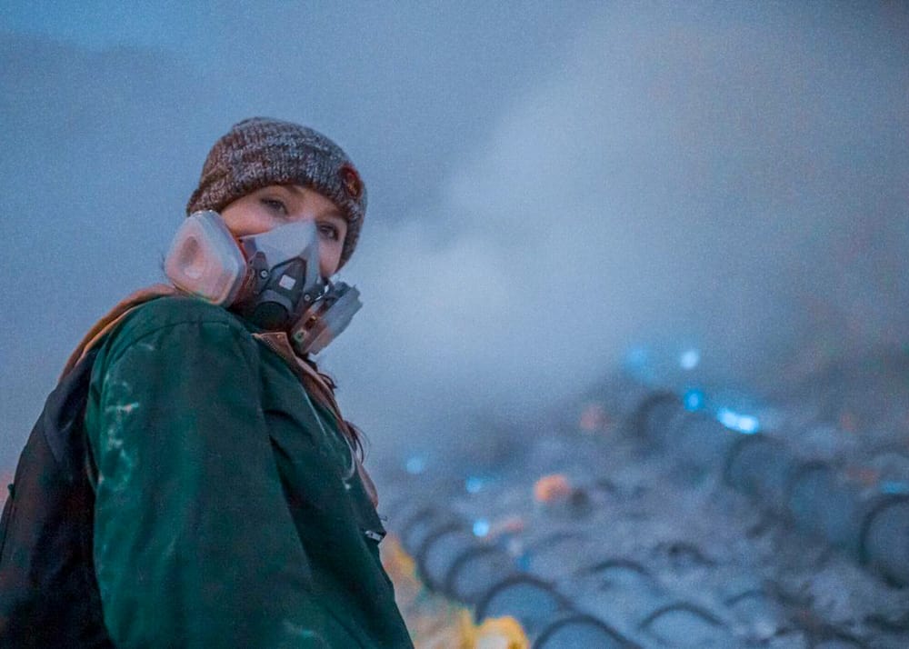 Blogger Katie Caf wears a gas mask next to the blue flames at Kawah Ijen Volcano in East Java, Indonesia.